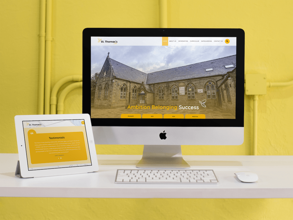St Thomas's website on mac & ipad next to yellow industrial wall